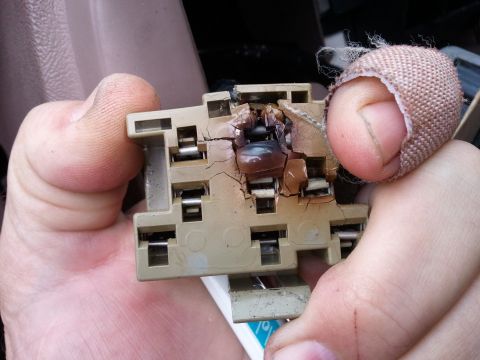 1994 Ford Bronco - A close-up shows a severely burnt electrical connector being held by two fingers, one of which is bandaged.