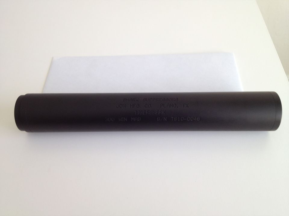 Black silencer with engraved text: "AVALON SUPPRESSORS", "JOH MFG. CO. PLANO, TX", "TIGER MARK", "300 1GN MAG", "P/N 1910-0046"