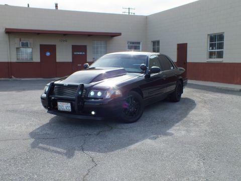 2003 Ford Crown Victoria - Front three-quarter of a black Crown Victoria Police Interceptor with EVIL VIC plate.