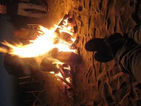 1989 Ford Bronco - Gathering around a warm campfire on a sandy beach at night.