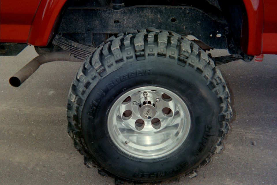 Red SUV rear tire with Super Swampers and chrome wheels