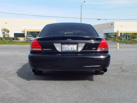 2003 Ford Crown Victoria - Straight-on rear shot of murdered-out Ford sedan with dual exhaust and INTERCEPTOR script.