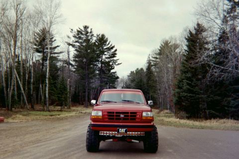 1995 Ford Bronco - This lifted 1995 Ford Bronco is shown from the front, a CAT license plate and auxiliary lights.