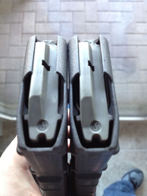 2013 Ford Mustang - Close-up view of two firearm magazines, highlighting their internal feeding components.