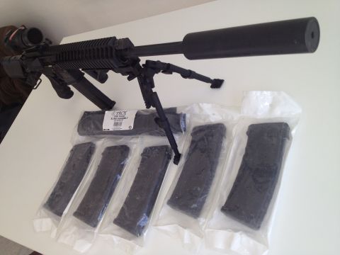 2013 Ford Mustang - Rifle with scope, bipod, suppressor, and magazines laid out on a table.