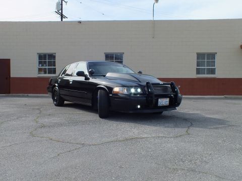 2003 Ford Crown Victoria - Lowered blacked-out sedan from the front quarter, push bar and California plate in view