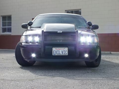 2003 Ford Crown Victoria - Head-on view showing the billet grille, dual HID beams and a California EVIL VIC plate reading Crown Victoria.