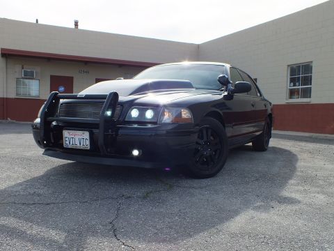 2003 Ford Crown Victoria - Close front-quarter view of the Interceptor showing twin projector HIDs, billet grille and grille guard.