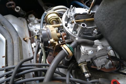 1978 Ford Bronco - The intricate details of a vehicle's engine, focusing on the carburetor and associated plumbing.