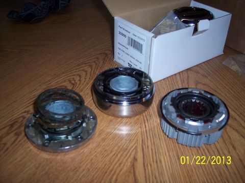 1973 Ford F-250 - Hubcap parts are laid out on a wooden floor next to an open box.