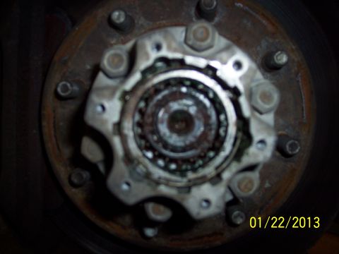 1973 Ford F-250 - Close-up of a rusty wheel hub assembly, likely from a truck, with visible bearings and bolts.
