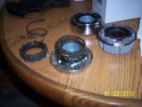 1973 Ford F-250 - Free-wheeling hubs and a gear ring are laid out on a wooden table.