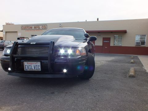 2003 Ford Crown Victoria - Front of a black Crown Victoria with brush guard and lights on outside Custom Mfg Co.