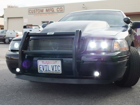 2003 Ford Crown Victoria - Front corner of a black Crown Victoria showing brush guard, fog lights and billet grille.