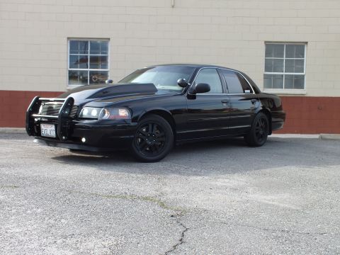 2003 Ford Crown Victoria - Black Crown Victoria with brush guard and projector headlights from the front left.