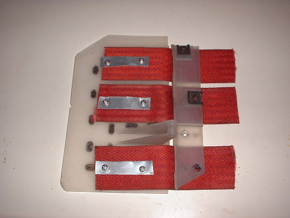 Fabricated translucent plastic panel with red webbing straps clamped by aluminum bars