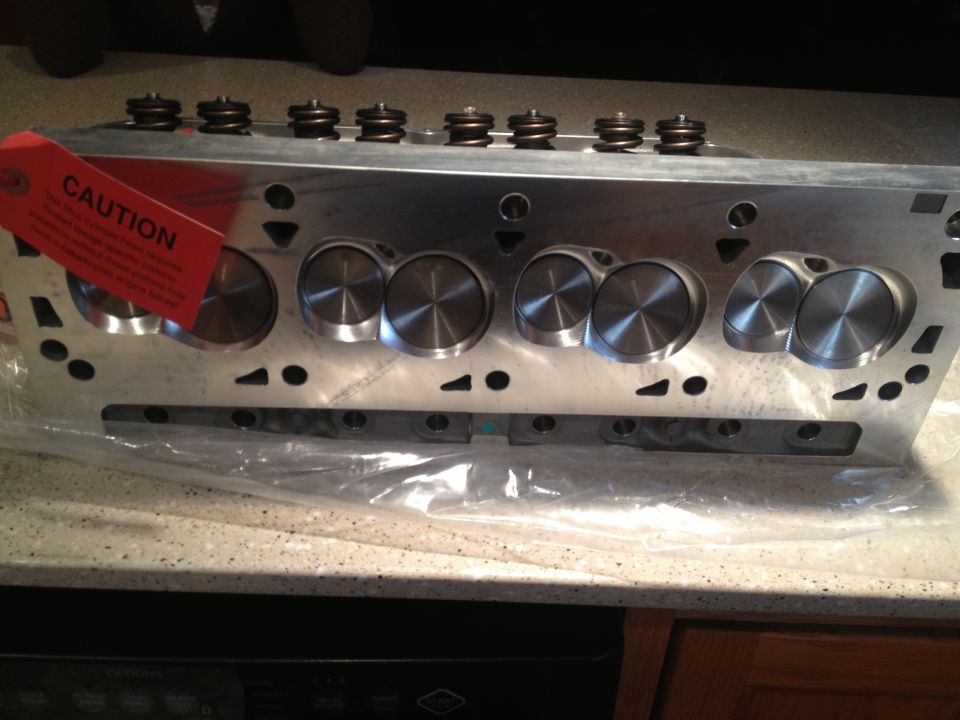 Aluminum cylinder head with installed valve springs and machined combustion chambers, CAUTION tag