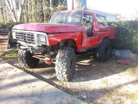 1978 Ford Bronco - This red SUV has been modified for off-road use with large tires and a lifted suspension.