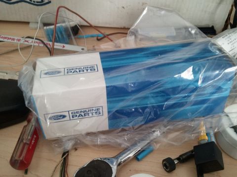 1994 Ford Bronco - Box of Ford genuine parts, likely for a vehicle, with various tools visible around it.