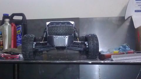 1996 Ford Bronco - A remote control rock crawler sits on a workbench next to bottles of fluid and tools.