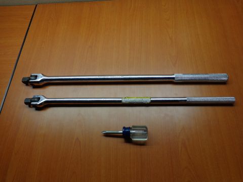 1965 Ford Mustang - A set of tools, including two breaker bars and a screwdriver, are laid out on a wooden table.