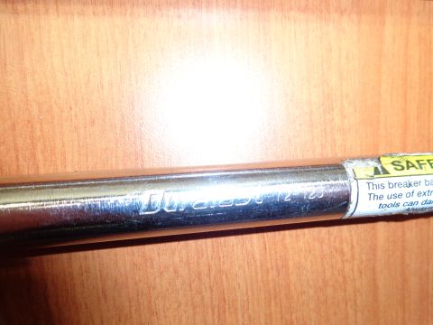 1965 Ford Mustang - A chrome breaker bar is shown with visible text indicating 'Duramax 1/2-125' and a safety warning label.