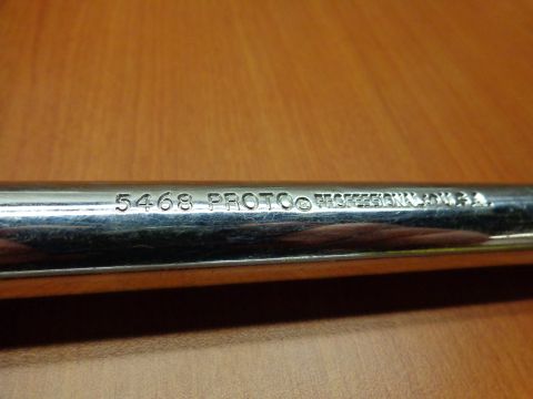 1965 Ford Mustang - Close-up of a chrome pipe showing engraved text including 'PROTO PROFESSIONAL USA'.