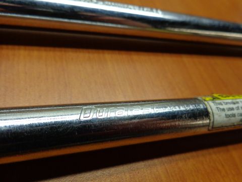 1965 Ford Mustang - Close-up of two chrome tool shafts, one with visible 'Duralast' branding and a warning label.