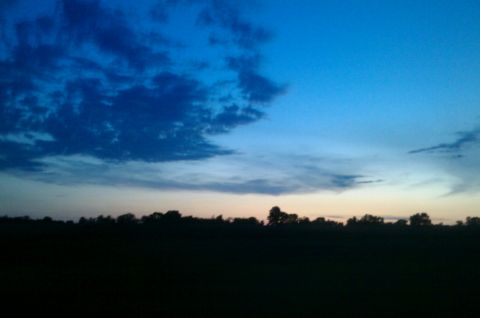 1987 Ford Bronco - A twilight sky with dark clouds above a silhouetted treeline.