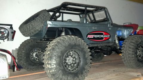 1993 Toyota 4Runner - This modified RC rock crawler features oversized tires, a full roll cage, and a 'Poly Performance' decal on its side.