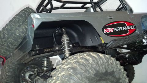 1993 Toyota 4Runner - Close-up of a remote-controlled rock crawler's rear suspension system and off-road tire.