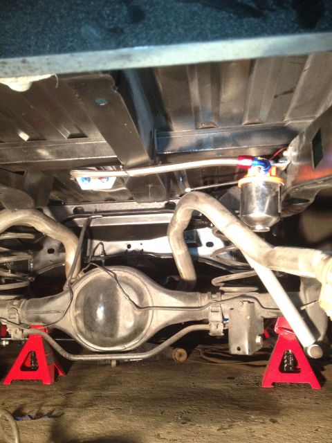1972 Ford Ranchero - The vehicle's undercarriage is visible, a rear differential, exhaust pipes, and a newly installed fuel filter.