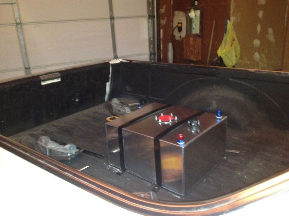 Aluminum fuel tank with red and blue caps in truck bed