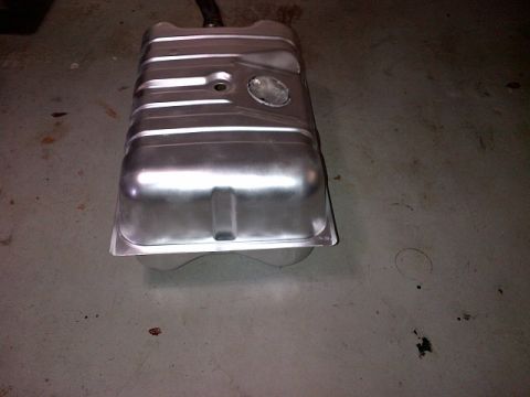 1994 Ford Bronco - A silver metal fuel tank is shown from a top-down perspective on a concrete floor.