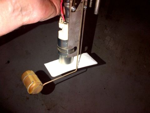 1994 Ford Bronco - Fuel pump assembly with float arm and filter, held by a hand.