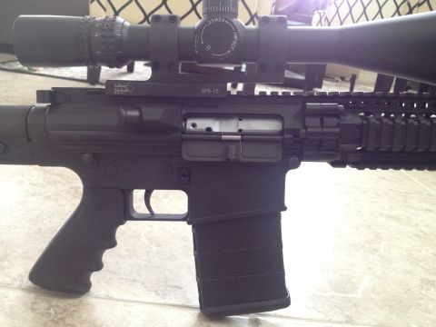2013 Ford Mustang - A close-up view of an assault rifle equipped with a scope and tactical accessories.