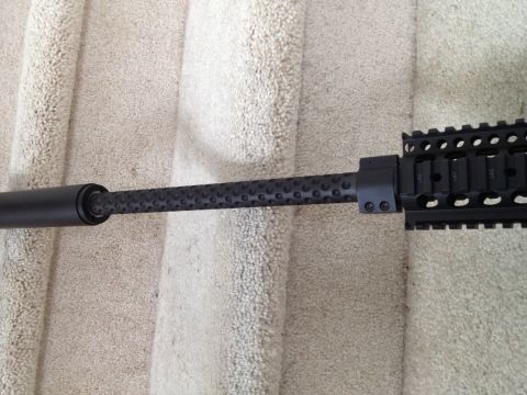 2013 Ford Mustang - Close-up of a firearm barrel a textured grip and a Picatinny rail system. The Supermotors.net logo is visible in the lower right corner.