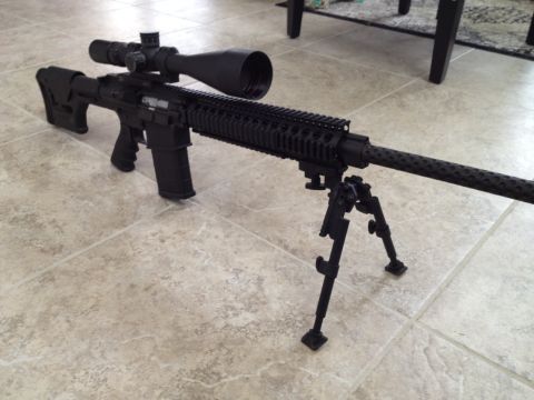 2013 Ford Mustang - A tactical rifle with a large scope and bipod is displayed on a tiled surface.