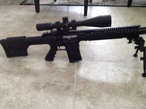 2013 Ford Mustang - A rifle with a scope and bipod is displayed on a tiled surface.