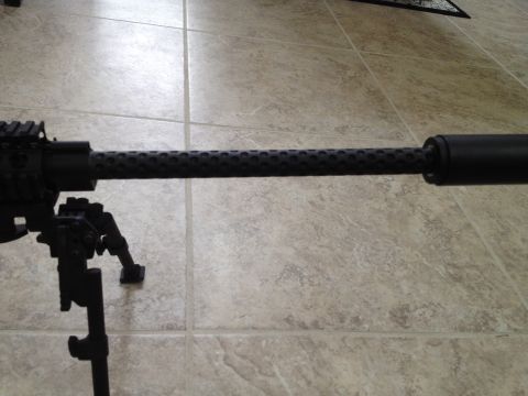 2013 Ford Mustang - A close-up view of a gun barrel with a perforated shroud and attached bipod, resting on a tiled floor.