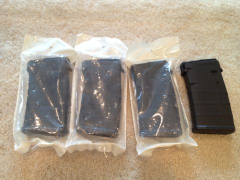 2013 Ford Mustang - Four black rifle magazines are shown, with three still in their original packaging.