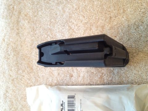 2013 Ford Mustang - A black plastic automotive part is shown on a carpeted surface, next to packaging with visible text and a website address.