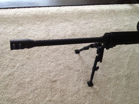 2013 Ford Mustang - A sniper rifle with a perforated barrel and bipod is shown resting on a carpeted surface. The image also contains a Supermotors.net waterma…