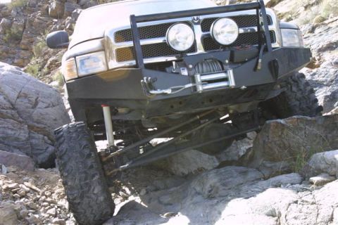 1994 Ford Bronco - This modified pickup truck is shown navigating a challenging rocky trail, demonstrating its off-road capabilities.