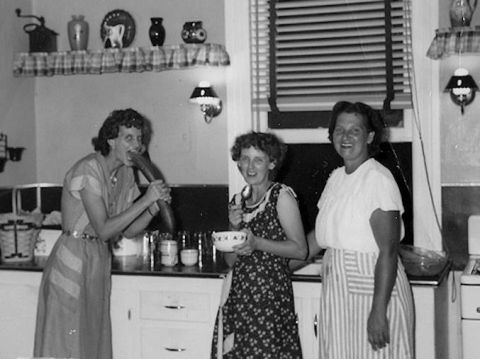 1971 Ford Ranchero - Three women are gathered in a kitchen, with one woman playfully holding a large vegetable near her mouth.