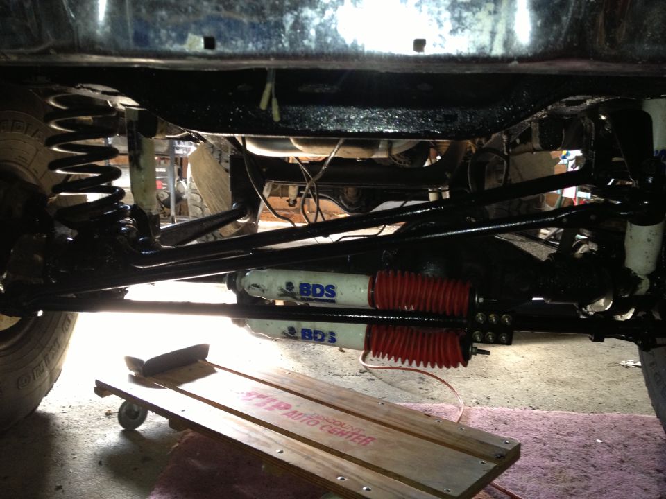 Undercarriage view showing suspension components and shocks with BDS branding. A wooden creeper is on the ground