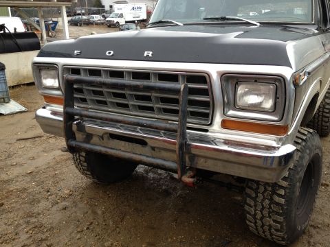 1979 Ford Bronco - The front grille and headlights of a 1979 Ford Bronco are visible, equipped with a heavy-duty brush guard.