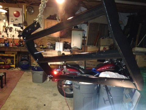 1979 Ford Bronco - A motorcycle is visible in a cluttered garage, with a large metal object suspended above it.