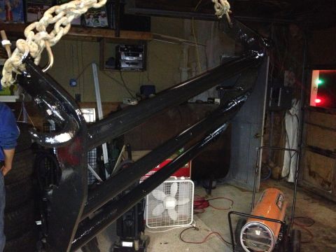 1979 Ford Bronco - A large black anchor hangs from a chain in a cluttered garage space.