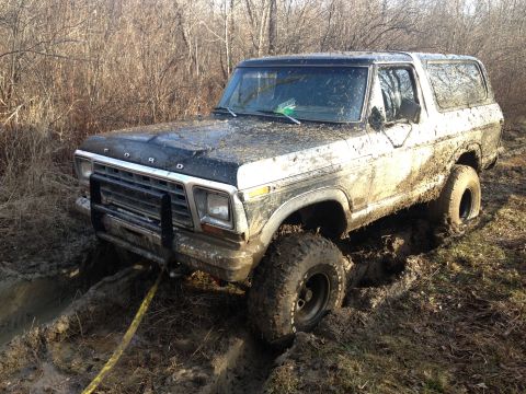 1979 Ford Bronco - This Ford Bronco is deep in the mud, with a tow strap ready to pull it out.